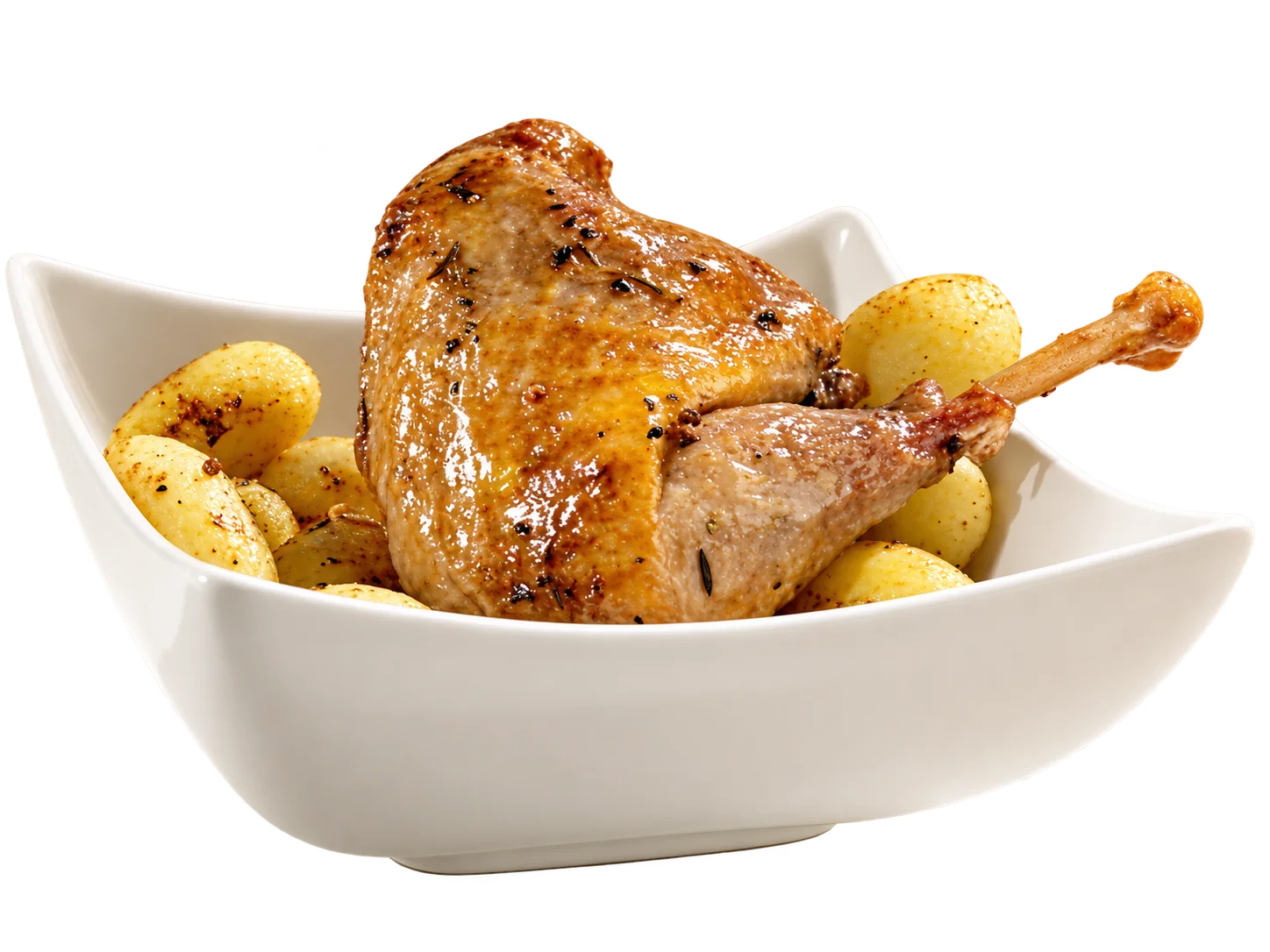 Une cuisse de volaille rôtie et dorée, parsemée d'herbes et de poivre, servie sur des pommes de terre sautées dans un bol blanc carré.